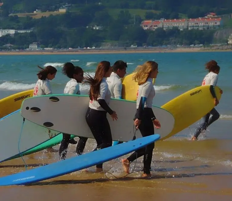 Grupo de jóvenes caminando por la playa hasta llegar a la orilla